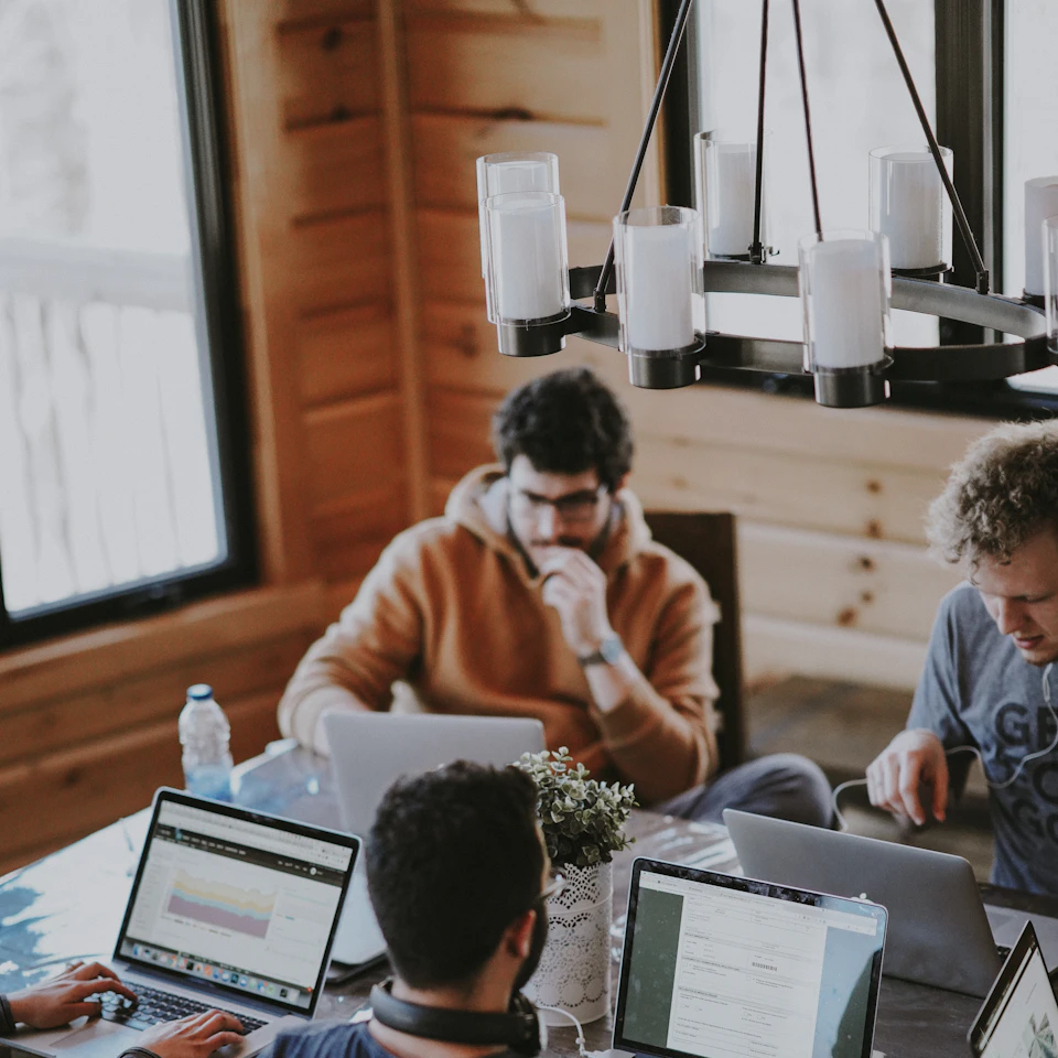 A team working together around laptops in an office